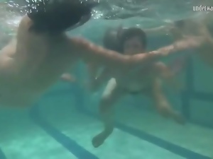 Naked girls dive into the pool for underwater fun