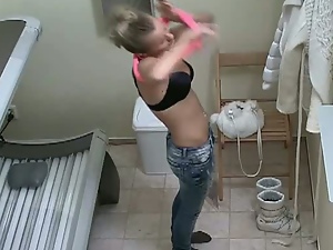 Sexy blonde taking off her clothes in solarium